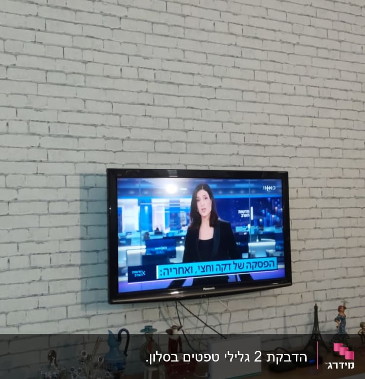 קיר לבנים לבן עם טלוויזיה תלויה